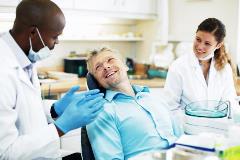 Dentist and hygienist with patient